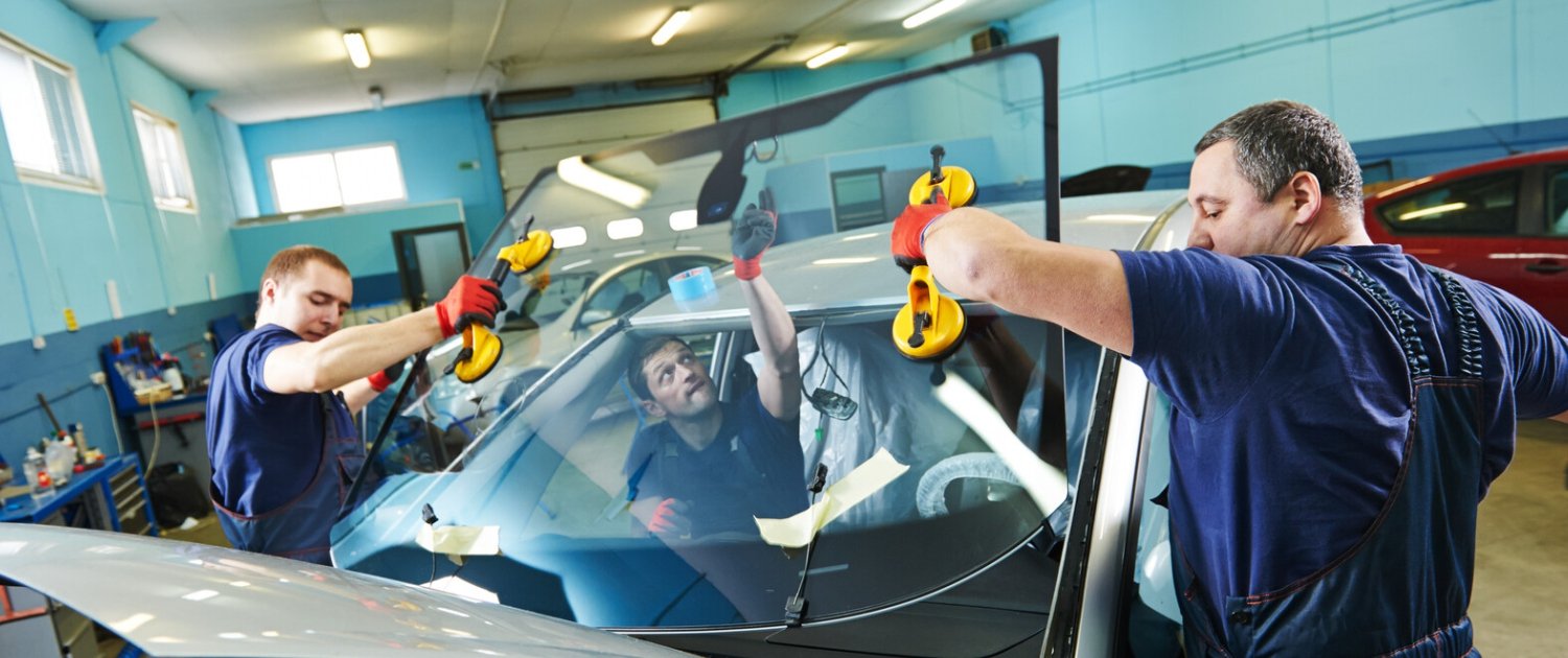 Auto glass technician replacing a vehicle windshield in Portland, OR